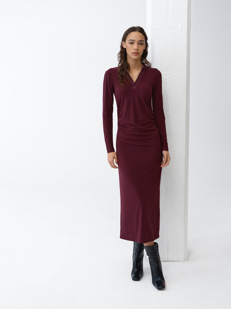 Woman wearing a long sleeve burgundy midi dress with collar