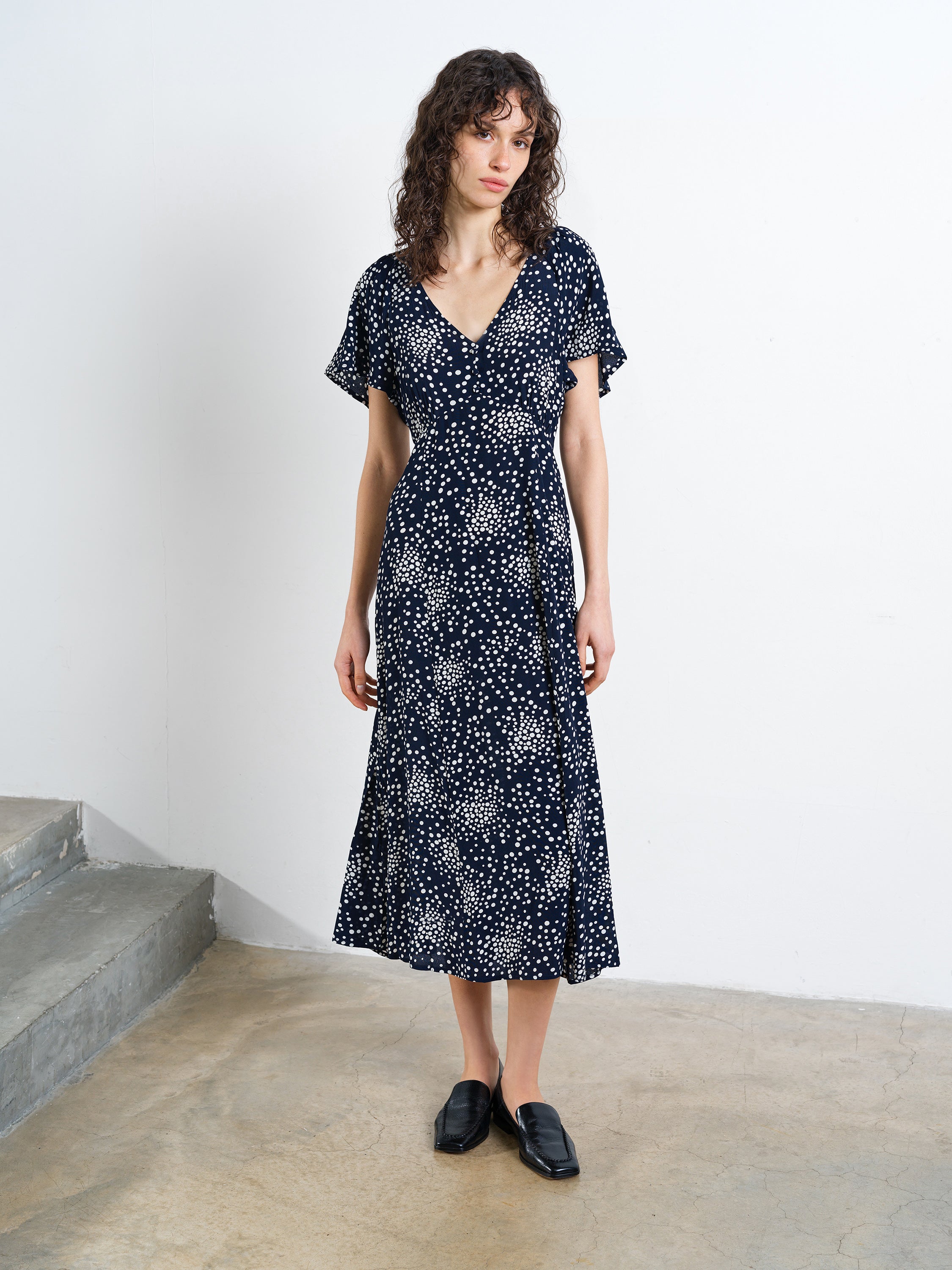 Woman wearing a navy and white abstract printed midi dress 