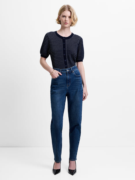 Woman wearing dark blue, slim straight leg jeans with a high waisted fit