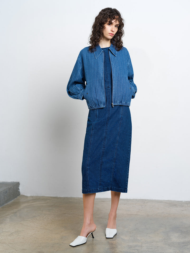 Woman wearing a long sleeve, blue denim pinstripe collared bomber jacket