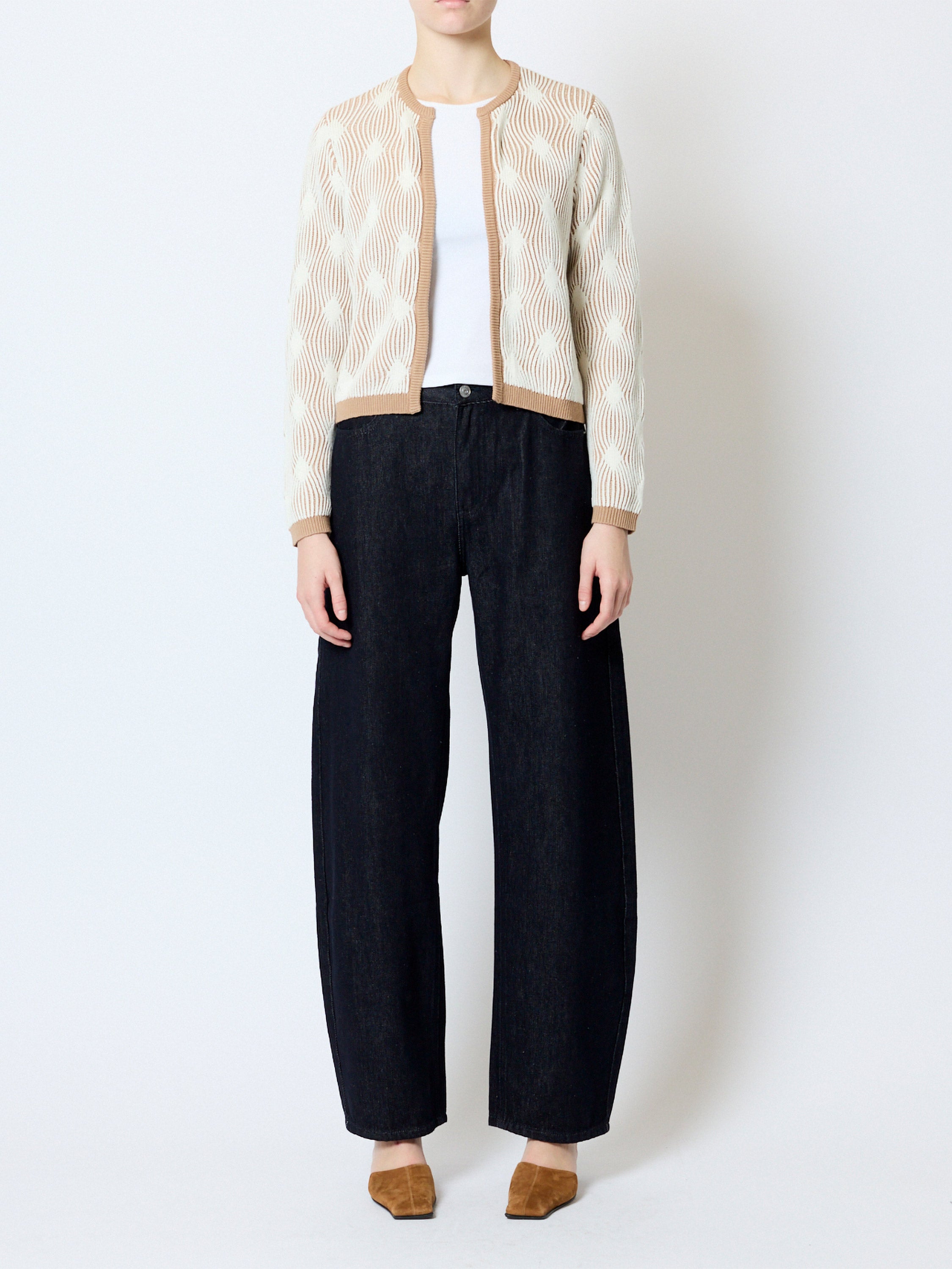 Woman wearing a wave jacquard print light brown crew neck cardigan, with a front hook fastening, boxy fit, and long sleeves.