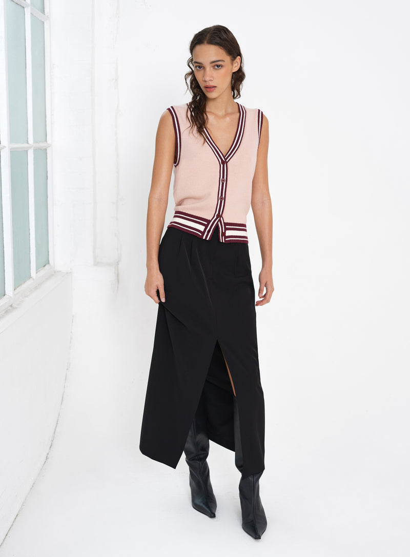 Woman wearing a sleeveless knitted button through vest top with a black midi skirt