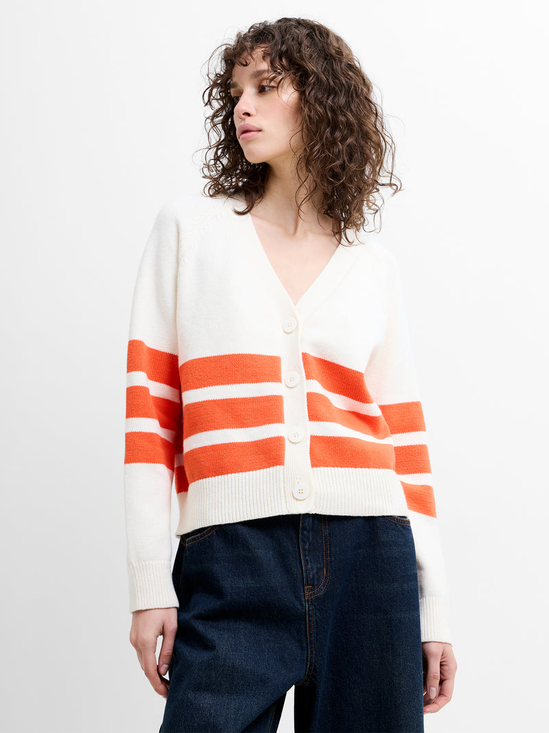 Person wearing a cream knitted cardigan with orange stripes